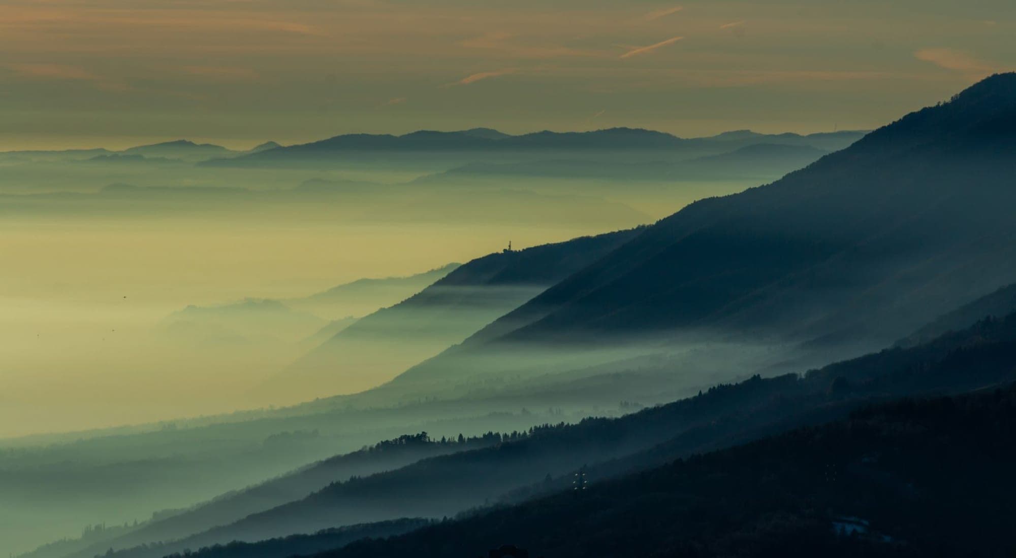 A mountain valley under soft dawn mist